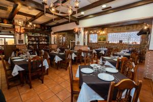 a restaurant with tables and chairs in a room at posada trastamara in Piedralaves