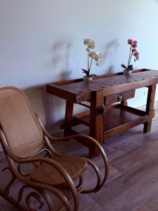 a wooden table with a chair and a wooden table with flowers at Dimora Gubbiano in Cascia