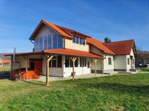 a house with a red roof on a green field at Bellevue Ciucas in Vama Buzăului