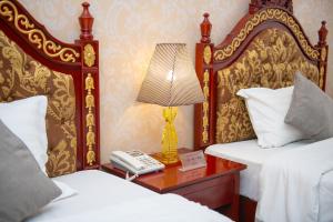 a bedroom with two beds and a lamp on a table at Fude Hotel T bilis第比利斯富德酒店 in Tbilisi City +40 photos