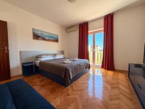 a bedroom with a bed and a large window at Pansion Palme in Drvenik