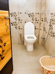 a bathroom with a toilet with flowers on the wall at Perfect View Homestay in Cherrapunji