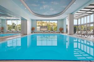 a swimming pool with blue water in a building at Ramada Plaza by Wyndham Mardin in Mardin