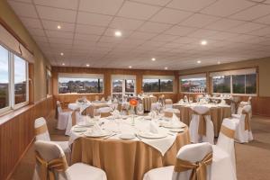 a conference room with tables and chairs and windows at Park Inn by Radisson Puerto Varas in Puerto Varas