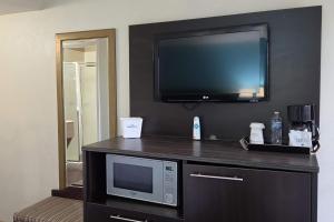 a room with a tv and a microwave on a counter at Howard Johnson by Wyndham Odessa TX in Odessa