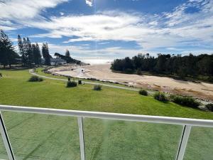 a view of the beach from the balcony of a building at Ocean Shores Apartment 15 - Bring your own linen. in South West Rocks