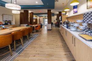 a restaurant with a long counter with chairs and tables at Comfort Inn & Suites New Iberia - Avery Island in New Iberia