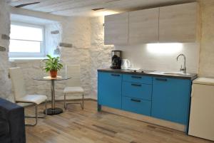 una cocina con armarios azules y una mesa pequeña en Aasa Apartments, en Tallin