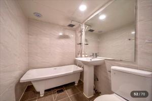 a bathroom with a tub and a sink and a toilet at 힐링모텔 in Inch'ŏn-yŏk