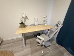 a desk with a chair and a table with flowers on it at Modern 2023 apartment in Kutno