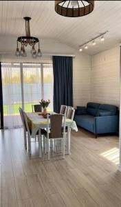 a living room with a table and a blue couch at Kashka-Suu house in Verkhnyaya Alaarcha