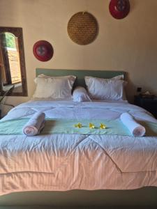 a bed with three pillows and three stars on it at pesisircottage & stay in Selong Belanak