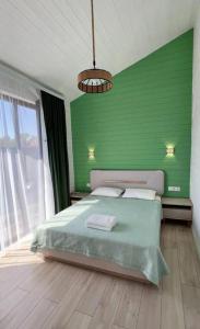 a green bedroom with a bed and a green wall at Kashka-Suu house in Verkhnyaya Alaarcha