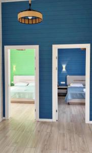 a room with two beds and a blue wall at Kashka-Suu house in Verkhnyaya Alaarcha +8 photos