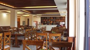 a dining room with wooden tables and chairs at ila Comfort Harkapur in Maruwā Ghāt