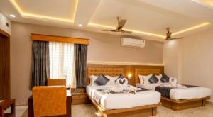a hotel room with two beds with swans on them at Taika Hotels, 1km Away from Main Temple in Rāmeswaram +19 photos