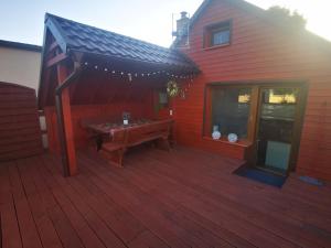 a wooden deck with a picnic table on a house at Agroturystyka Od Kaszuba in Żuromino
