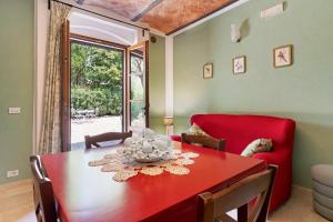 a dining room with a red table and a red chair at Agriturismo Santa Luce in Foiano della Chiana