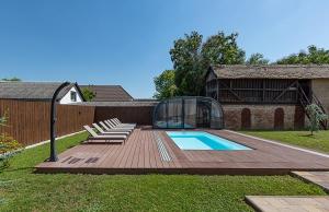 a backyard with a glass house and a swimming pool at Adamkó Borkert Ház in Villány