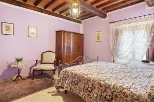 a bedroom with a bed and a chair at Agriturismo Santa Luce in Foiano della Chiana