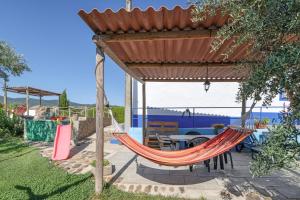 a hammock under a gazebo in a garden at Monte Corte Enchária in São Teotónio