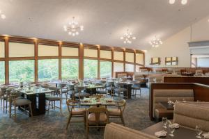 a dining room with tables and chairs and windows at Hilton Chicago/Northbrook in Northbrook