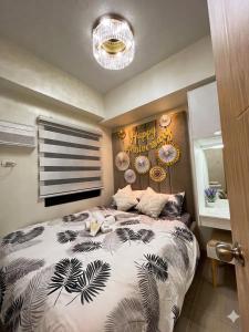 a bedroom with a bed with a black and white comforter at Jade Mantle Sanctuary in Manila