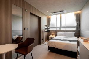 a hotel room with a bed and a table and chairs at My Me Hotel in Seoul