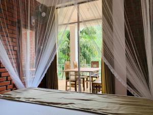 a bed in a room with a large window at Rawana Mountain View Homestay in Ella