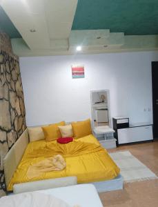 a bedroom with a bed with a yellow blanket at Samaya in Agigea