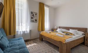 a bedroom with a bed and a blue chair at Adamkó Borkert Ház in Villány +18 photos