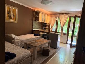 a small room with two beds and a table at Paunovi Guest House in Primorsko