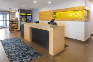a lobby with a home sign on a counter at Home2 Suites by Hilton Gillette in Gillette +26 photos