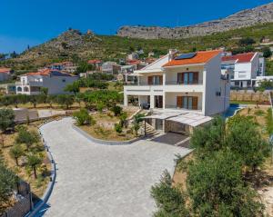 an aerial view of a house with a hill in the background at Villa Botanica near Split - Heated Pool and Garden in Kučine
