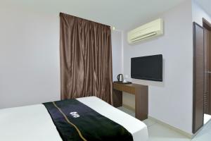 a hotel room with a bed and a tv at Dancenter Hotel Shah Alam in Shah Alam