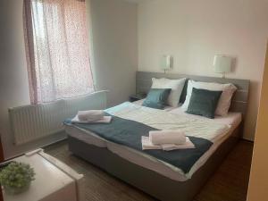 a bedroom with a bed with two towels on it at Hotel u Freuda Příbor in Nový Jičín