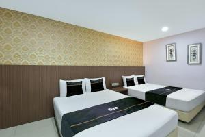 a hotel room with two beds in it at Dancenter Hotel Shah Alam in Shah Alam