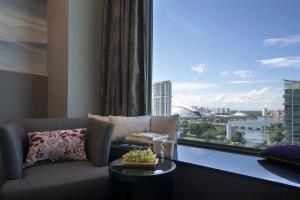 ein Wohnzimmer mit Sofa und großem Fenster in der Unterkunft V Hotel Lavender in Singapur