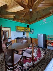 a dining room with a table and chairs and a kitchen at Shantiloka - Private 1BHK Homestay in Kulu