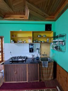 a kitchen with a stove and a sink at Shantiloka - Private 1BHK Homestay in Kulu
