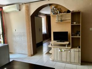 a living room with a tv and a tv stand with a flat screen at Paunovi Guest House in Primorsko