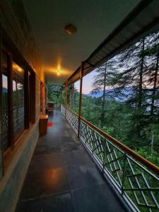 a balcony of a building with a view of the forest at Shantiloka - Private 1BHK Homestay in Kulu