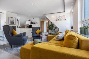 a living room with a yellow couch and chairs at To Huus am Steinhuder Meer in Steinhude