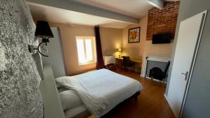 a small bedroom with a bed and a fireplace at Hôtel Restaurant de la Place in Saint-Jean-dʼAngély