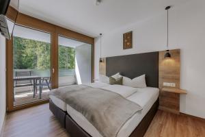 a bedroom with a large bed and a balcony at Apartment Waldesruh in Oetz
