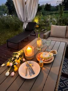 a table with plates of food and candles on it at New Generation Camp in Siedliska