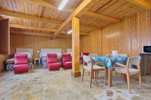 a dining room with a table and red chairs at Vivienda Jardin in Monforte de Lemos