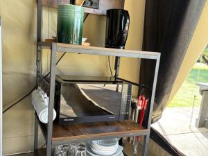 a microwave on a shelf in a kitchen at Kameeldoring Camping & Tented Chalets in Kakamas +44 photos