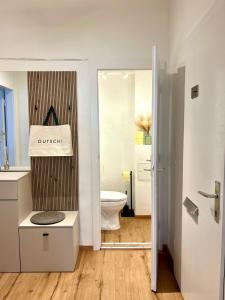 a bathroom with a toilet and a sign that says queens at Mountain Nest Apartment in Schottwien