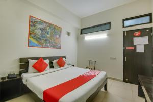 a bedroom with a large bed with red pillows at Hotel O Dream View in Gurgaon